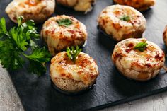 some food that is sitting on a black tray and garnished with parsley