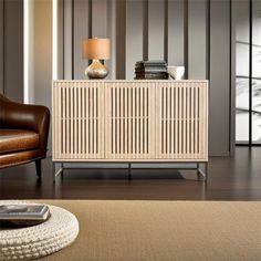 a living room with a brown chair and a wooden cabinet in the middle of it