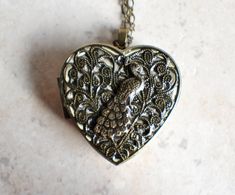 an ornate heart shaped locke with a bird on it's back, sitting on a marble surface