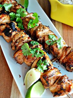 a white plate topped with meat covered in cilantro