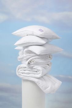 a stack of pillows sitting on top of a white pole