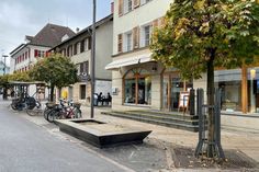 there are many bikes parked on the side of the street in front of shops and buildings