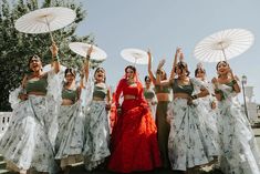 a group of women standing next to each other holding umbrellas