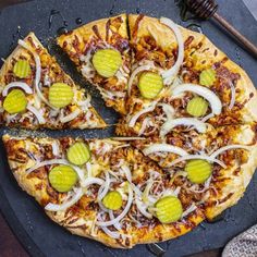 a pizza with onions, cheese and pickles on it