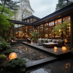 an outdoor living area with couches, tables and lights on the ground in front of it