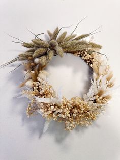 a wreath made out of dried flowers and leaves