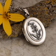 May birth flower locket necklace in 925 sterling silver with a working compass inside and a place for your favorite photo. May's birth flower is Lily of the valley.  This dainty bell shaped flower connotes fidelity, sweetness and purity. Those born in May are wholesome loyal friends, enjoy innocent pursuits and parenthood. This lovely sterling silver oval locket features a lovely detailed Lily of the valley on the front. The locket has been given an oxidized patina and hand buffed to bring out silver highlights.  Inside the silver locket is a small vintage Japan working compass.  Across from the compass is a place for your favorite photo. Unisex Necklace For Him Or Her Unique Birth Flower Locket, Travel Necklace by DesignsBloom The back of this sterling silver compass locket is smooth.  If Compass Locket, Flower Lily Of The Valley, May Birth Flower, May Birth Flowers, Born In May, Silver Locket Necklace, Travel Necklace, Picture Locket, Silver Highlights