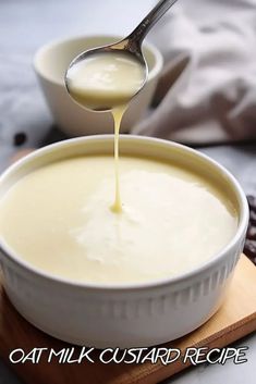 a spoon drizzling liquid into a bowl of food on top of a cutting board