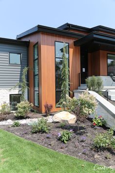 a modern home with wood siding and landscaping