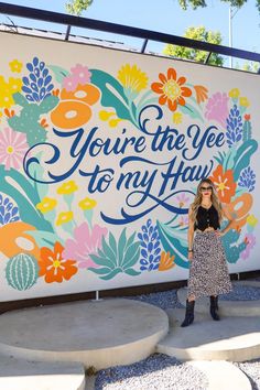 a woman standing in front of a sign that says you're the yee to my hau