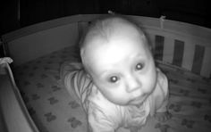 a baby in a crib looking at the camera