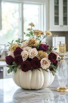 a white pumpkin filled with flowers on top of a counter