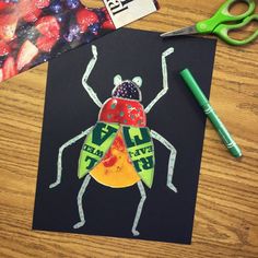 a paper cut out of a ladybug on top of a table with scissors