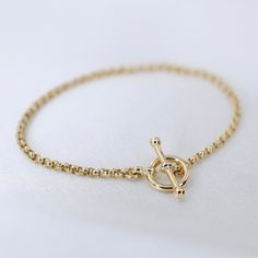 "14K GoldToggle Rolo Chain Bracelet - 14K Gold 2mm Rolo Chain Bracelet ★ 14K gold 2mm rolo chain ★ 14K gold toggle clasp ★ All components are 14K solid yellow gold The length includes the chain and the closure. Please measure your wrist before you place your order. ** How to choose a correct size of bracelet. 1. Measure your wrist below the wrist bone using a flexible tape measures, a string or a strip of paper. 2. If using a string or a strip of paper, mark length. Then, measure it with a ruler Gold Chain Bracelet For Everyday, Classic Gold Bracelet With Toggle Clasp, Yellow Gold Plated Bracelet With Toggle Clasp, Yellow Gold-plated Bracelet With Toggle Clasp, Everyday Yellow Gold Chain Bracelet With Toggle Clasp, Classic Yellow Gold Bracelet With Toggle Clasp, Everyday Yellow Gold Bracelets With Toggle Clasp, Elegant Yellow Gold Bracelet With Toggle Clasp, Elegant Yellow Gold Toggle Necklace Tarnish Resistant