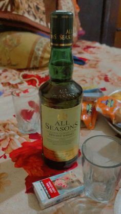 a bottle of wine sitting on top of a table next to a glass and napkin