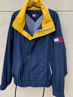 Vintage 90’s Tommy Hilfiger hoodie windbreaker jacket ! In blue and yellow colors, with spell out on collar and big flag logo ! In excellent condition ! Marked size L, but please refer to measurements ! Measurements Pit to pit: 28" Sleeves: 33” (from the collar seam down)  Length: 30” (base of collar to bottom of back) ~~~~~~~~~~~~~~~~~~~~~~~~~~~~~~~~ Please Note: In the unlikely event that you encounter an issue with your purchase, please contact me so that I can help you resolve the problem Casual Hooded Tommy Hilfiger Windbreaker, Tommy Hilfiger Casual Hooded Windbreaker, Tommy Hilfiger Hooded Streetwear Outerwear, Hooded Tommy Hilfiger Outerwear For Streetwear, Tommy Hilfiger Hooded Outerwear For Streetwear, Tommy Hilfiger Sporty Streetwear Windbreaker, Tommy Hilfiger Casual Outdoor Windbreaker, Tommy Hilfiger Sporty Windbreaker For Streetwear, Tommy Hilfiger Hooded Windbreaker For Fall