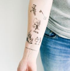 a woman's arm with tattoos on it and various things drawn on the arm