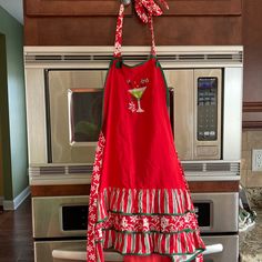 a red apron hanging on a kitchen stove