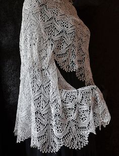 a crocheted shawl is displayed on a mannequin