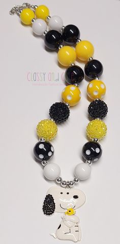 This listing is for one Snoopy bubblegum beaded necklace.  Use drop down box to chose your length. Available from 16 to 20 inches in length.  20mm black, yellow and white solid beads. 20mm black and yellow rhinestone beads.   20mm yellow polka dot beads and black polka dot beads.  6mm silver spacer beads. Metal enamel pendant is 2 inches in size. Necklace has a lobster clasp closure with a 2 inch extender chain. Product color may differ slightly due to photographic lighting sources or your monit Cute Adjustable Yellow Necklaces, Cute Adjustable Yellow Necklace, Fun Black Jewelry For Birthday, Cute Yellow Round Bead Necklaces, Fun Yellow Jewelry For Birthday, Yellow Beaded Necklace With 8mm Beads As Gift, Cute Customizable Black Jewelry, Personalized Yellow Round Bead Jewelry, Customizable Adjustable Yellow Jewelry