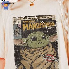 a woman wearing a star wars t - shirt with an image of baby yoda on it