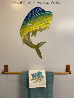 a fish is hanging on the wall above a towel rack