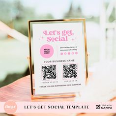 a pink and gold business card sitting on top of a wooden table