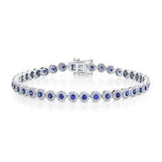 Rich in color, she will love the deep blue hues in this bracelet from Shy Creation. Crafted in 14k white gold, this bracelet features a row of blue sapphire gemstones surrounded by sparkling round diamonds in a halo motif. This bracelet measures 4.5mm in width and 7 inches in length. The diamonds are 1 1/4ctw, H in color, and SI2 in clarity. Blue Sapphire Diamond Round Bracelet, Blue Diamond Bracelet With Prong Setting, Blue Diamond Bracelet With Prong Setting For Anniversary, Blue Diamond Bracelet In Prong Setting, Sapphire Tennis Bracelet With Jubilee Design, Blue Brilliant Cut Diamond Bracelet, Blue Diamond Bracelet With Brilliant Cut, Blue Sapphire Round Tennis Bracelet, Blue Sapphire Gemstone Tennis Bracelet