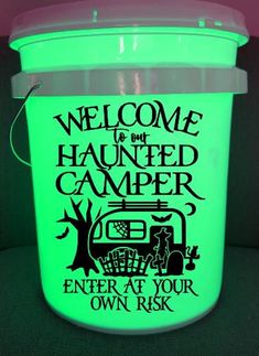 a neon green bucket with the words welcome to the haunted camper on it and an image of a tree