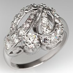 This lovely circa 1950s ring features a ribbon design and is accented with one (1) old European cut diamond set into a four-prong head and twenty-three (23), bead set, round brilliant/single cut diamonds. The ring measures 15.3mm at the top, rises 7.9mm above the finger, tapering to 2.0mm wide and 0.9mm thick at the base of the shank. This ring is currently a size 8. Vintage Diamond White Diamond Ring For Formal Occasions, Elegant Round Cut Diamond Ring With 17 Jewels, Vintage Single Cut Diamond Ring For Formal Occasions, Vintage Single Cut Diamond Ring For Formal Events, Art Deco Brilliant Cut Diamond Ring For Vintage Events, Vintage Diamond Ring For Vintage Events, Vintage Round Diamond Ring For Vintage Events, Vintage Diamond Ring With Prong Setting For Formal Occasions, Vintage Round Diamond Ring For Formal Occasions