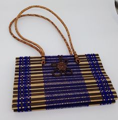 Thailand Purse Handbag Woven Straw Rattan Purple Handmade Flower Brown Womens This is a nice preowned purse handbag from Thailand.  This was a gift and was never used.  It is hand crafted with rattan and thread and grass.  It has a decorative flower on the front that hooks around and closes on the back.  It has a double handle that is woven.  Inside it is lined with black fabric and has one pocket and has a tag which says, "Made in Thailand". The purse without the strap measures approximately 5. Rectangular Beach Bag With Bamboo Handle, Traditional Bags With Bamboo Handle For Everyday Use, Traditional Bag With Bamboo Handle For Everyday Use, Traditional Rectangular Bags With Bamboo Handle, Rectangular Bags With Bamboo Handle For Gift, Rectangular Bag With Bamboo Handle As Gift, Rectangular Bag With Bamboo Handle For Gift, Traditional Rectangular Shoulder Bag With Bamboo Handle, Natural Color Bag With Bamboo Handle For Gifts