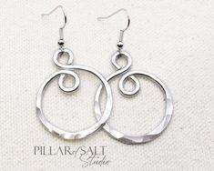 These handcrafted earrings are super light and just might become your new go-to pair. These shiny and lightweight earrings were handcrafted from thick aluminum wire, hammered for that great texture that catches the light, and then tumbled for greater shine and strength. The ear wires are solid stainless steel. They hang about 1 3/4" from the piercing (the spiral itself is about 1 1/4" long) and are approximately 1" wide. The pair you receive will vary slightly from the pair in the photos due to the handmade nature but will be very similar. Seriously lightweight, and seriously shiny!! * Aluminum (10th anniversary gift). * Stainless steel ear wires. * Lightweight. * Length: 2" from the piercing. Please don't hesitate to ask questions. Wire Bracelets Diy, Hammered Wire Jewelry, Aluminum Wire Jewelry, Wired Jewelry, Jewelry Hacks, Aluminum Earrings, 10th Anniversary Gifts, Wire Wrap Jewelry Designs, Wrapped Rings