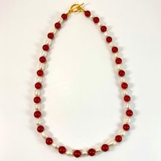 18.5" Strung pomegranate red natural stone beads and natural freshwater pearl beads with gold clasp. Matching earrings with gold s-hooks Elegant Red Beaded Necklaces With Natural Stones, Elegant Red Beaded Necklace With Natural Stones, Elegant Red Beaded Necklace With Lobster Clasp, Elegant Red Round Pearl Necklace, Elegant Red Pearl Necklace With Gemstone Beads, Red Pearl Necklace With Gemstone Beads, Red Pearl Necklace With Pearl Drop, Elegant Single Strand Red Pearl Necklace, Elegant Red Single Strand Pearl Necklace