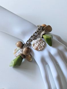 "Fabulous Vintage 1940s 1950s Chunky Green Swirled Bakelite, Mother of Pearl, Wood, Mother of Pearl Discs, and Metal \"Shells\" Charm Bracelet.  Fold over clasp.  Very good vintage condition with only Minor wear.  Wearable length seems to be 7 1/2\"" Retro Green Bracelet Jewelry, Vintage Polished Beads Bracelet, Vintage Polished Beads Bracelet Jewelry, Vintage Polished Bead Bracelet, Vintage Adjustable Bracelet With Polished Beads, Vintage Adjustable Stretch Bracelet With Large Beads, Vintage Adjustable Bracelets With Polished Beads, Vintage Beaded Bracelets For Jewelry Making, Handmade Vintage Green Beaded Bracelets