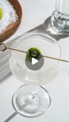 a martini glass with an olive garnish in it