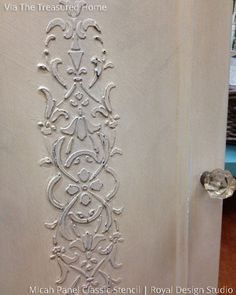 the door is decorated with an intricate design on it's side panel and has been painted white