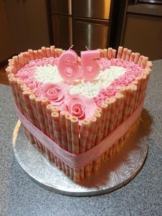 a heart shaped cake with pink icing and roses