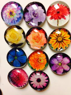 many different colored flowers in glass cabochons