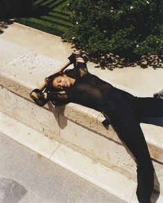 a woman is laying on the steps with her legs crossed and head resting on her hand