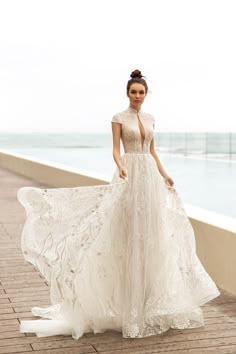 a woman in a white dress standing on a pier