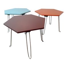 three tables with different colored tops and metal legs, one on top of the other