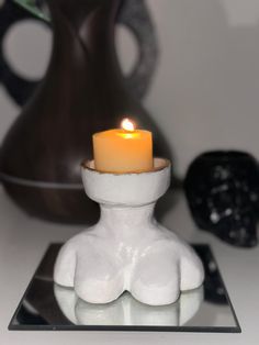 a candle is sitting on a glass plate