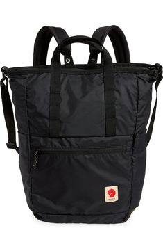 a black backpack with straps on the front and side pockets, it has a zippered pocket