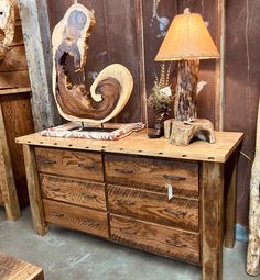 a wooden dresser sitting next to a lamp on top of a table