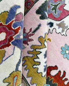 four different colored rugs with designs on them and one is pink, blue, green, red