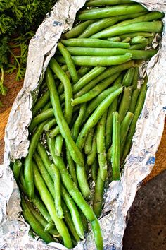 some green beans are in tin foil on a table