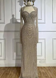 This Champagne Long Sleeve Cutout Mock Neck and Back Bead Embellished Gown is a masterpiece of sophistication and style. This gown features a luxurious champagne hue that exudes elegance, with a sleek, fitted silhouette that enhances the figure. The mock neck adds a touch of refinement, while cutouts on the front and back introduce a bold, contemporary edge. Intricate bead embellishments cascade across the gown, adding a subtle shimmer and texture that elevate its luxurious appeal. The long slee Katib Kitab, Pink Long Sleeve Dress, Crystal Dress, Champagne Pink, Feather Tops, Casual Cosplay, Embellished Gown, Thousand Oaks, Black Tie Event