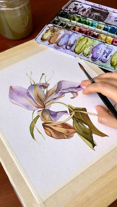 a person is painting flowers with watercolors