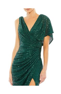 Dazzling emerald sequins illuminate this glamorous gown designed with a dipped cowl back and a daring side vent. 62 1/2" length V-neck Single short sleeve Lined Asian Owned/Founded 100% polyester Spot clean, dry flat Imported Dropping Dress, Plastic Dress, Trumpet Gown, Hugging Silhouette, Prom Designs, Designer Prom Dresses, Evening Dresses Cocktail, Mac Duggal, Mesh Overlay