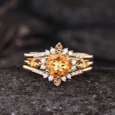 an orange and white diamond ring sitting on top of a rock